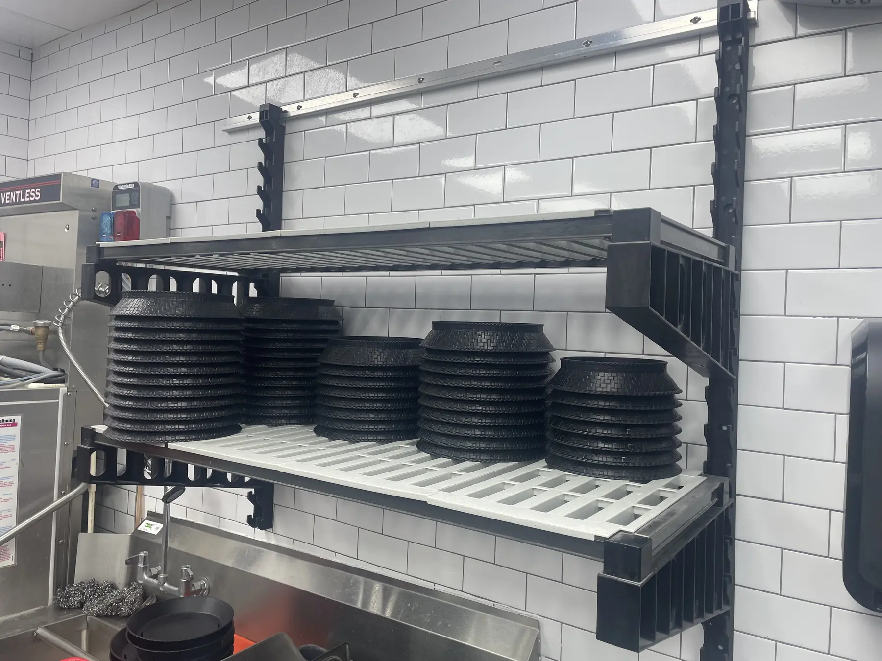 Stacks of plates stored on a wall-mounted shelving system